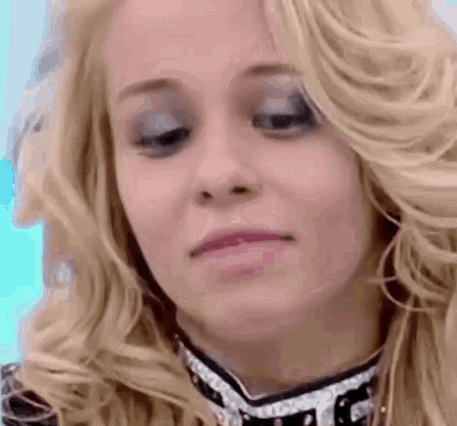 a close up of a woman 's face with blonde hair making a face .