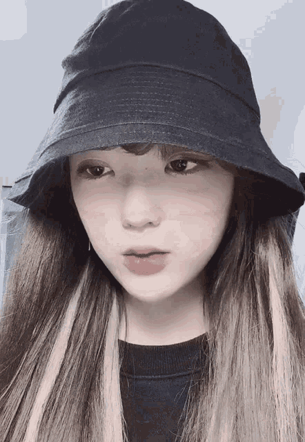a woman wearing a black bucket hat and a black shirt