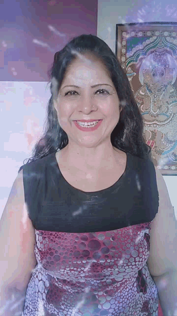a woman is smiling in front of a painting of a deity