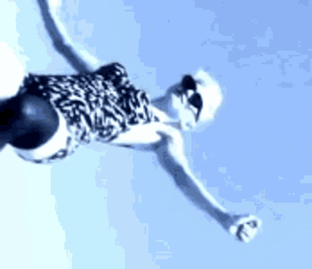 a woman in a zebra print dress is flying through the air