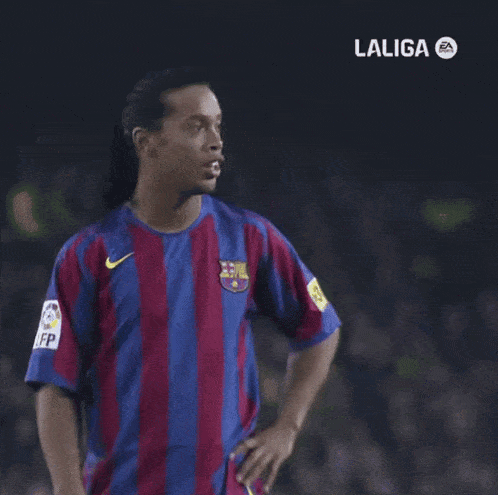 a man in a laliga shirt is pointing at something