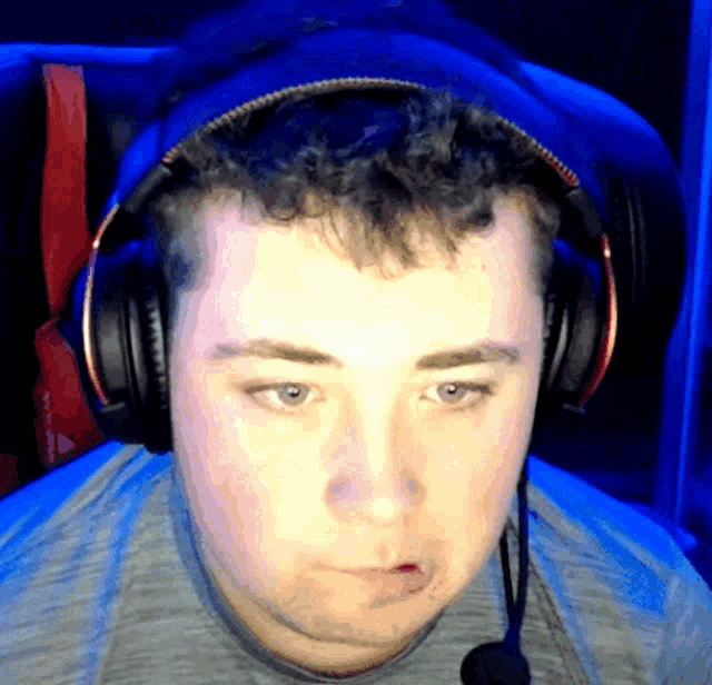a man wearing headphones and a microphone is making a face
