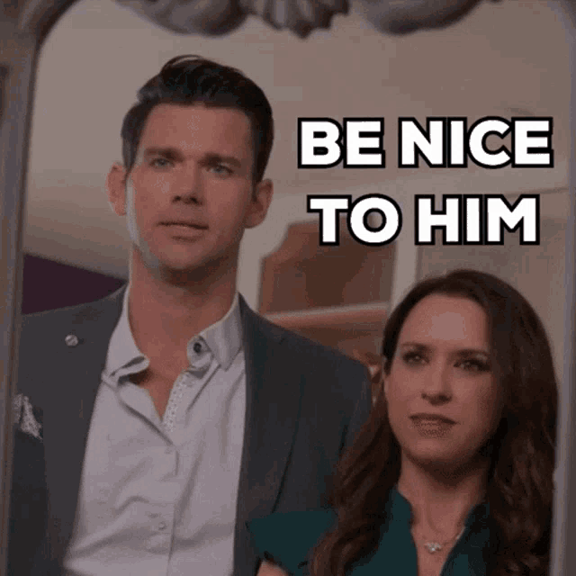 a man and a woman are standing in front of a mirror with the words be nice to him written above them