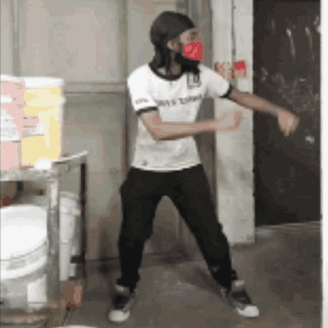 a man wearing a white shirt and black pants is dancing in a room .
