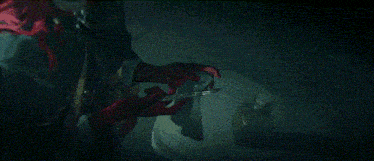 a person wearing red gloves is holding a pair of scissors in their hand