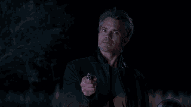 a man pointing a gun with the words it 's not not what we 're saying above him