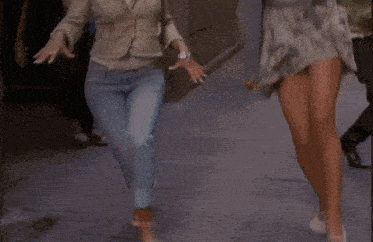 two women are running down a street with their arms outstretched and one is wearing a pearl necklace
