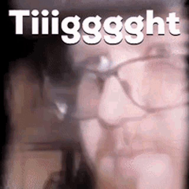 a close up of a woman 's face with glasses and the words tiiiggght written above her .