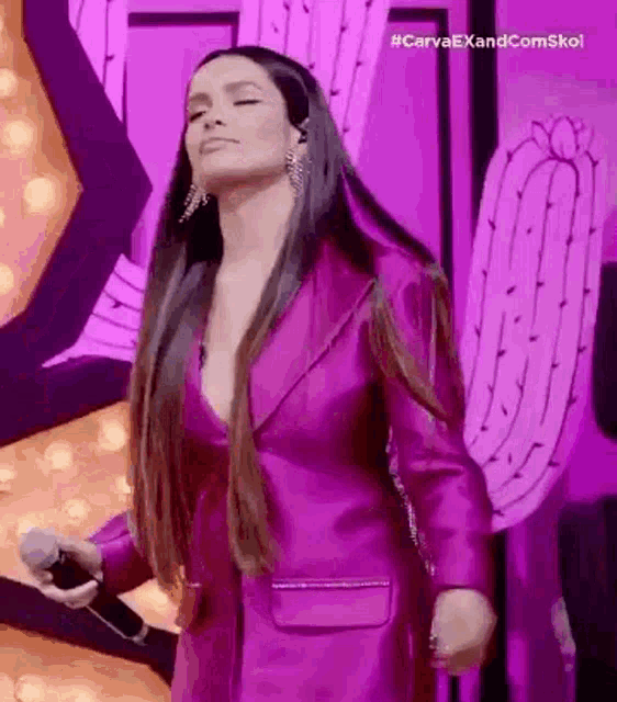 a woman in a purple jacket is dancing on a stage .
