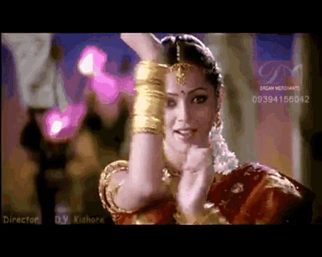 a woman in a red and gold dress is dancing in front of a screen that says director