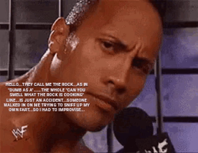 a close up of a man talking into a microphone with the word wwe on his chest