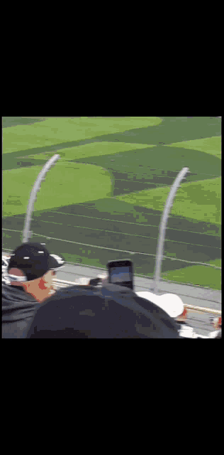 a man is taking a picture of a race track with a cell phone