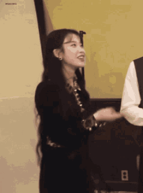a woman in a black dress stands next to a man in a white shirt
