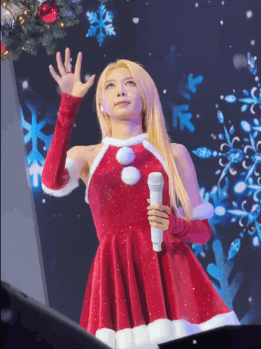 a woman in a santa claus dress holds a microphone