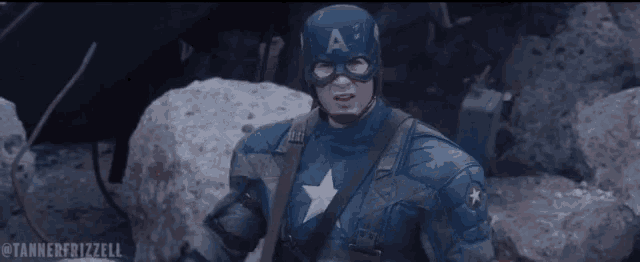 a man in a captain america costume stands in front of rocks