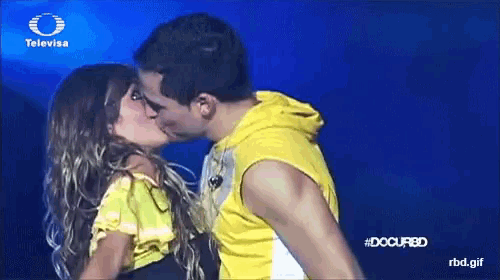 a man and woman are kissing on a television screen