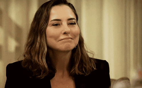 a woman in a black jacket is making a face