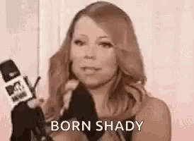 a woman is holding a microphone and talking into it while wearing gloves .