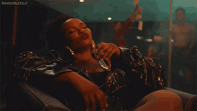 a woman laying on a couch holding a glass of wine with randomlessly written on the bottom right