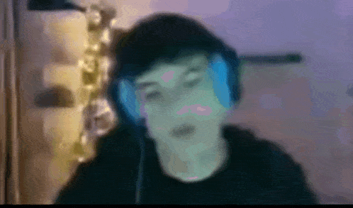 a blurry picture of a man wearing headphones in a dark room .
