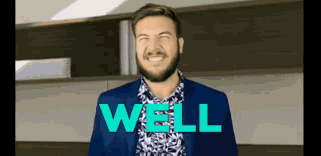 a man with a beard wearing a blue suit and a shirt with the word well on it .