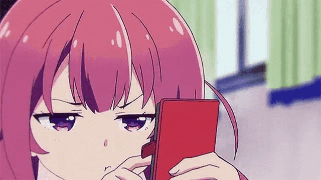 a girl with purple hair is looking at a cell phone .