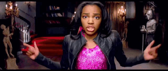 a girl in a pink sequined top and a black leather jacket is making a funny face