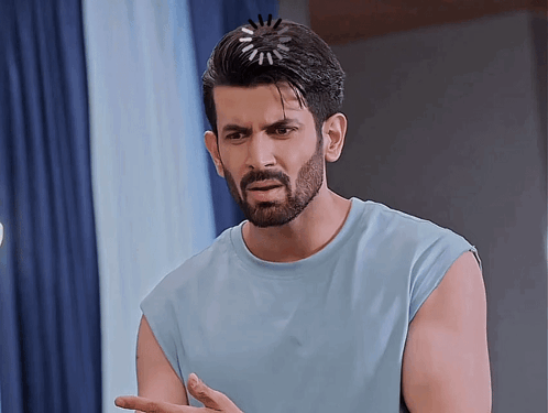 a man with a beard wearing a blue sleeveless shirt