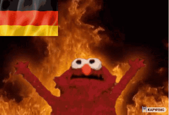 elmo is standing in front of a german flag and fire