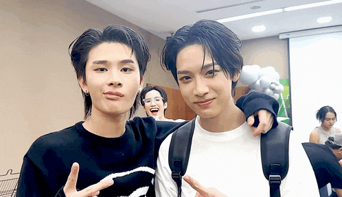 two young men are posing for a picture and one has a backpack