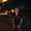 a man with his arms outstretched is standing in front of a fire .