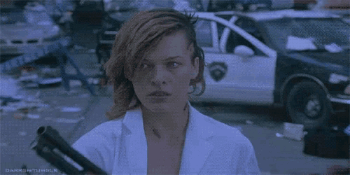 a woman in a white lab coat is holding a gun in front of a police car .