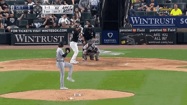 a baseball game is being played with a wintrust ad in the outfield