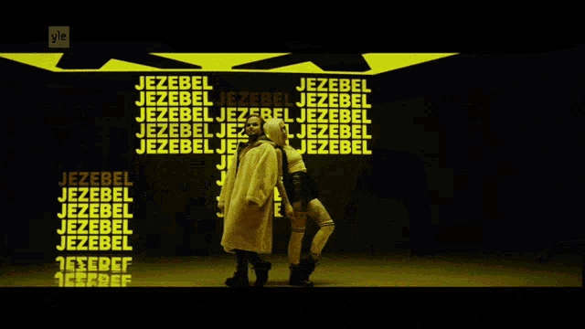 a woman is playing a guitar in front of a sign that says jezebel jez