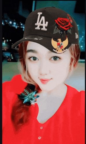 a woman wearing a black la hat with a rose on it