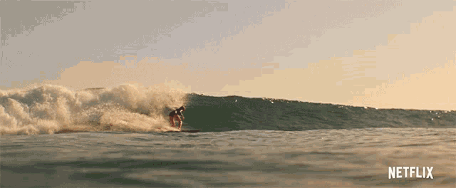 a surfer is riding a wave with a netflix logo in the corner