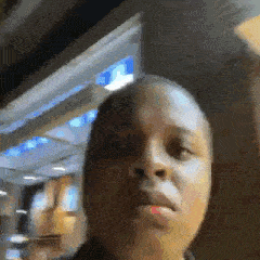 a close up of a person 's face in a room with a blurry background .