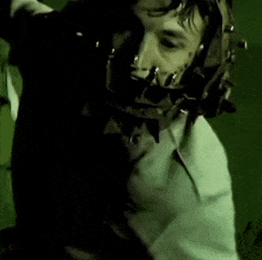 a man is wearing a mask with spikes on his face .