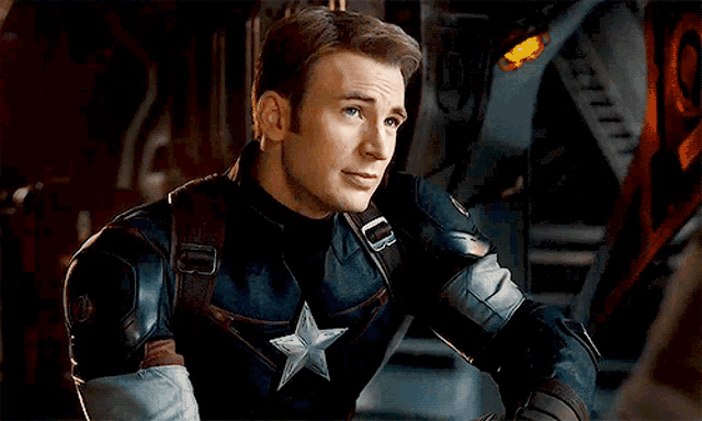 a close up of a man in a captain america uniform looking away from the camera .