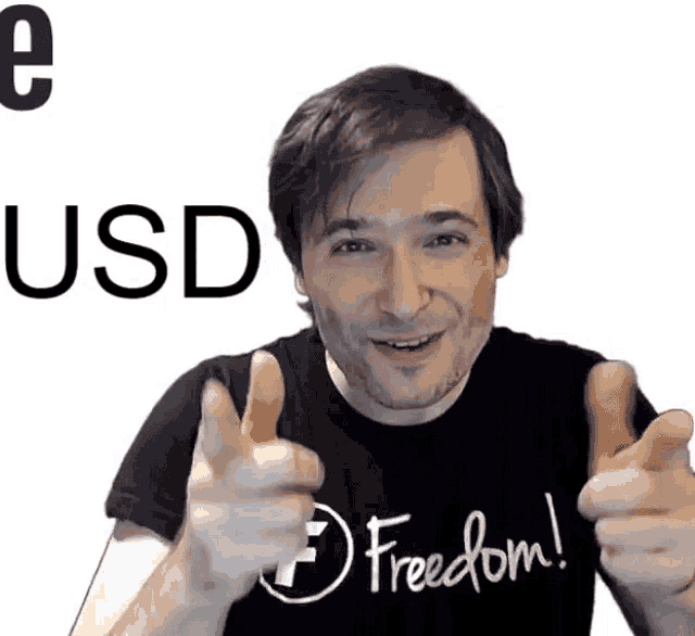 a man wearing a black shirt that says freedom is giving a thumbs up