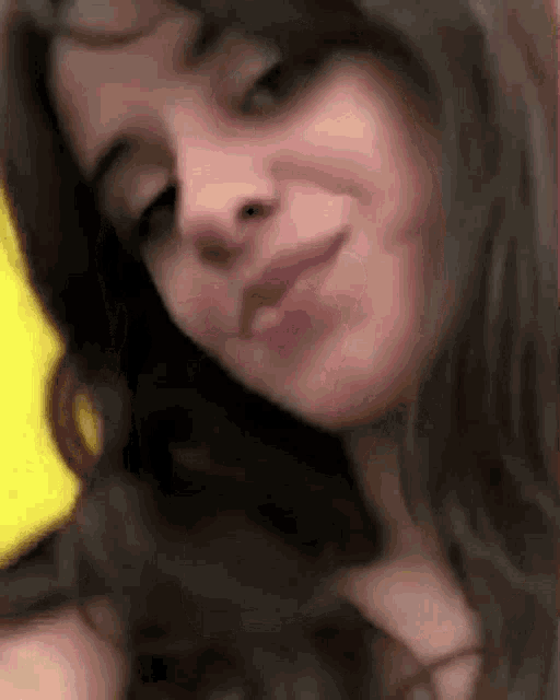 a close up of a woman 's face with her eyes closed and a yellow background .
