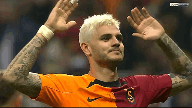 a soccer player is waving his hands in the air while wearing a jersey that says ' bein sports ' on the bottom