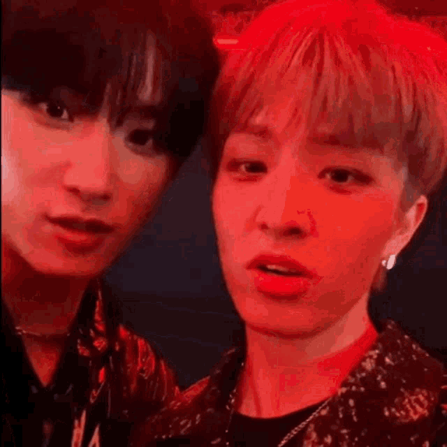 a couple of young men are standing next to each other in a dark room .