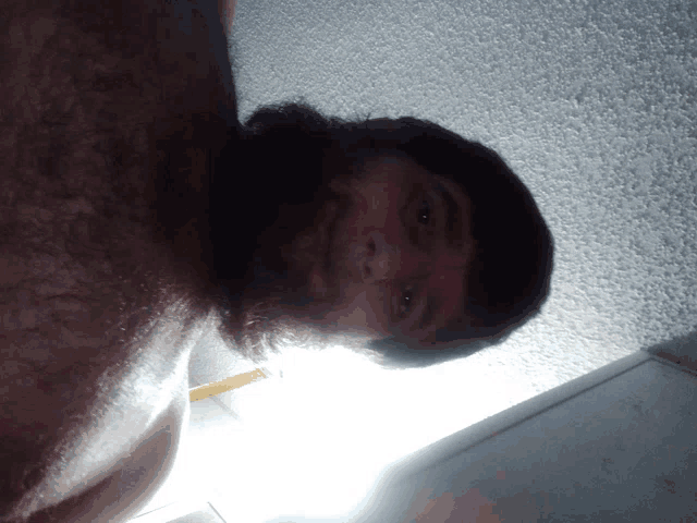 a man with a beard is looking down at the camera