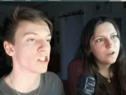 a man and a woman are standing next to each other and looking at the camera .