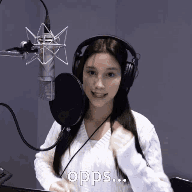a woman wearing headphones stands in front of a microphone with the word opps on the bottom