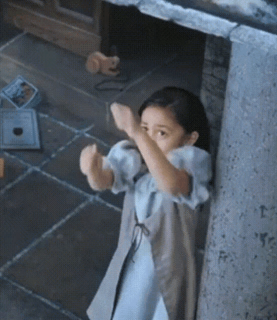 a little girl is making a funny face while standing in a room .