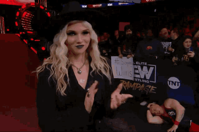 a woman in a top hat holds a sign that says " senpai wins "