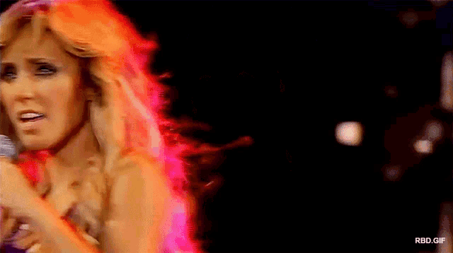 a woman singing into a microphone with the words rbd.gif written below her