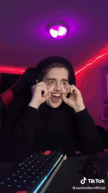 a man is making a funny face while sitting in front of a keyboard